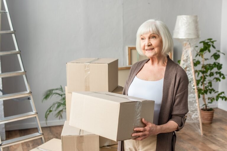 cheerful senior woman holding cardboard box and lo 2023 11 27 05 02 58 utc