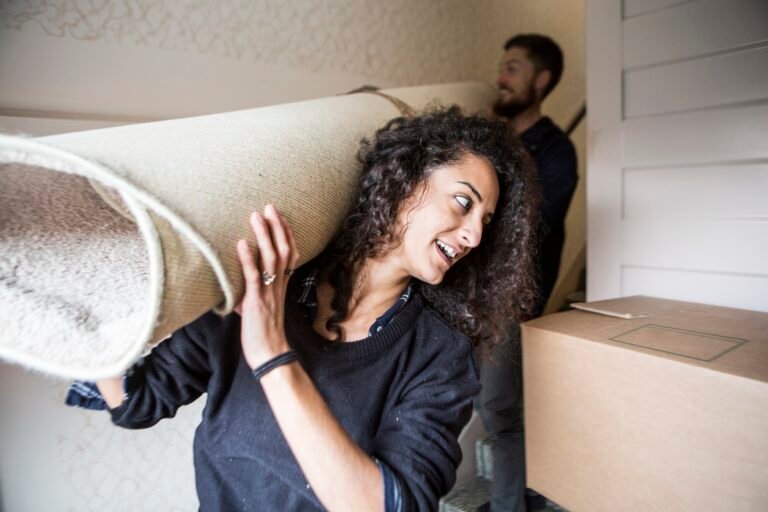 woman and man carrying carpet while moving house 2023 11 27 04 56 31 utc