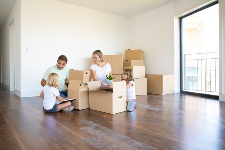 happy parents two kids moving into new empty apartment sitting floor near open boxes 74855 10023
